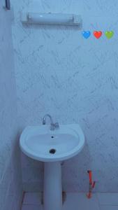 ein weißes Waschbecken in einem Badezimmer mit Herzen an der Wand in der Unterkunft bookingvilla in Yof