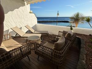 a patio with chairs and tables and the ocean at Costa Teguise luxury first line apartment in Costa Teguise