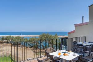 a balcony with tables and chairs and a view of the beach at Villa Vincenza Deluxe Rooms in Capo dʼOrlando +33 photos
