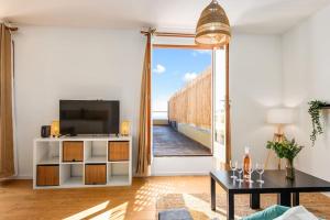 a living room with a tv and a large window at Maison savorani in Cap d'Ail