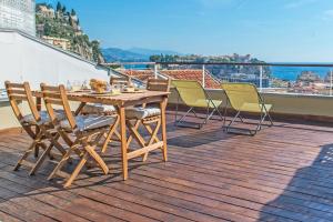 a wooden table and chairs sitting on a roof at Maison savorani in Cap d'Ail