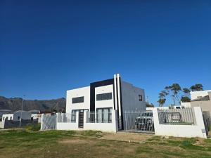 a white house with a fence in front of it at Aqua Breeze in Cape Town