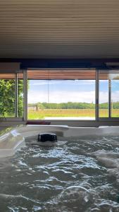 a room filled with water with a large window at L’Instant in Caupenne