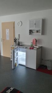 a small white kitchen with a sink and a refrigerator at Monteurzimmer in Schwendi