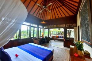 a bedroom with a bed with a ceiling fan at Kavita 1 BR Grand Deluxe Valley View ZN236 in Ubud