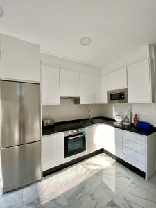 a kitchen with white cabinets and stainless steel appliances at SHR043 Nerja Medina Apartamento cerca de Playa Torrecilla in Nerja