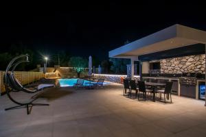 a patio with a table and chairs next to a pool at Charaki Dream Villas in Haraki