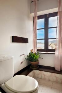 a bathroom with a toilet and a window at MANGA BLUE'S GUEST HOUSE in Fianarantsoa