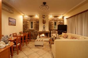 a living room with a couch and a fireplace at Politia Villas in Karistos
