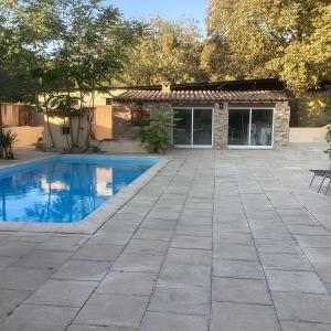 Un patio con piscina y una casa. en La bergerie Emma, en Éoures