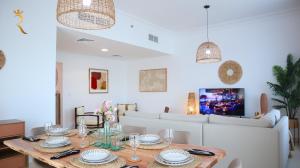 Un comedor con una mesa y un sofá. en Elegant 2BR Golf View Oasis in Yas Island - Maids Room, Pool & Near Yas Mall, en Yas Island