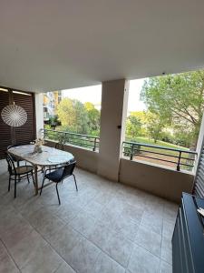 a balcony with a table and chairs on a patio at L éden mer et piscine appartement 53 m2 in Saint-Aygulf