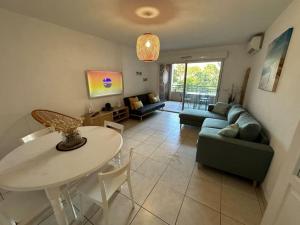 a living room with a table and a couch at L éden mer et piscine appartement 53 m2 in Saint-Aygulf