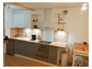 a kitchen with stainless steel appliances and a table at Plage à 2mn à pieds in Carnon-Plage