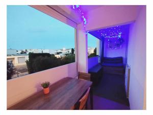 a balcony with a table and a window with purple lights at Plage à 2mn à pieds in Carnon-Plage +11 photos