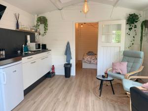 a kitchen and living room with a couch and a table at Tiny house tussen de grachten in Sneek