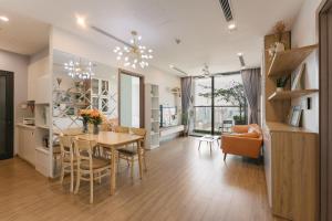 a dining room and living room with a table and chairs at LUXURY APARTMENT VINHOMES SKYLAKE 5min to KEANGNAM in Hanoi