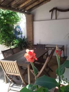 a wooden table and chairs on a patio with a flower at La Carrihuela Amarilla in Algodonales