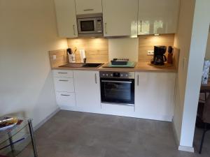 a small kitchen with white cabinets and a stove at Appartement Moselblick in Cochem