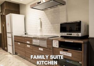a kitchen with a family suite kitchen with a refrigerator at Hotel Pasela Living Shinjuku in Tokyo