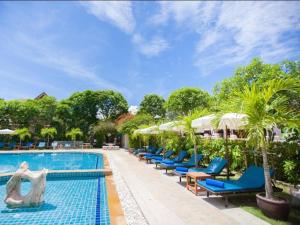 - une piscine avec des chaises bleues et des parasols dans l'établissement Blue Beach Apartment, à Rawai Beach