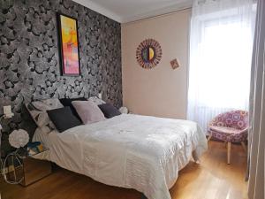 a bedroom with a large bed and a wall with a picture at maison piscine clos ,wifi, 2 chambres près de la mer in Bourgneuf-en-Retz