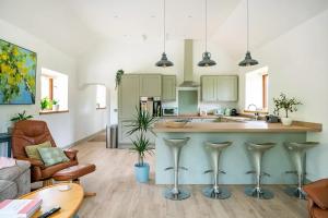 a kitchen with a large island in a living room at The Barn at Burfords with wood fired hot tub in Monksilver