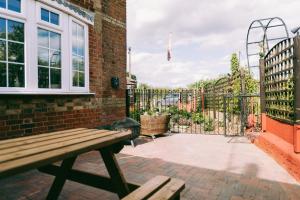 a patio with a wooden bench and a gate at 1 Bed Free Parking Pets Allowed in East Dereham