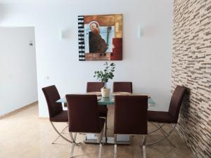a dining room table with chairs and a painting on the wall at Roque's House in Telde