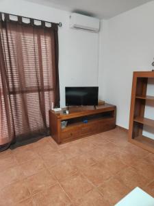 Μια τηλεόραση ή/και κέντρο ψυχαγωγίας στο Casa Baja tranquila con terraza y jardín en Vera-Playa naturista!