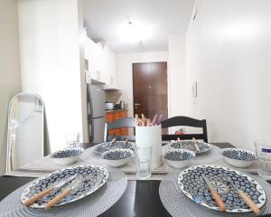 a table with blue and white bowls and wooden chopsticks at Cubao Manhattan Heights Residential Condo TC10N - Bright Studio with Pool, Balcony - Next to AliMall and SM - Walking Distance to Araneta Coliseum and Gateway Mall in Cubao Quezon City - Staycations by SMS in Manila