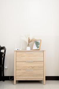 a wooden dresser with a picture on top of it at Cubao Manhattan Heights Residential Condo TC10N - Bright Studio with Pool, Balcony - Next to AliMall and SM - Walking Distance to Araneta Coliseum and Gateway Mall in Cubao Quezon City - Staycations by SMS in Manila