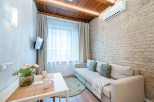 a living room with a couch and a brick wall at Warm studio in the heart of city in Vilnius