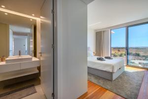 Un dormitorio con una cama, un lavabo y un espejo. en Cond Bayline - T2 - SPA - POOL - GYM - WIFI - Nemo - BY BEDZY, en Armação de Pêra 37 fotos más
