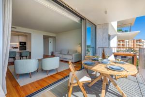 Un comedor y una sala de estar con mesa y sillas. en Cond Bayline - T2 - SPA - POOL - GYM - WIFI - Nemo - BY BEDZY, en Armação de Pêra