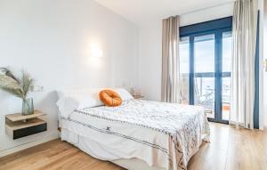 トレモリノスにあるCozy Apartment In Torremolinosのベッドと大きな窓のある白い寝室