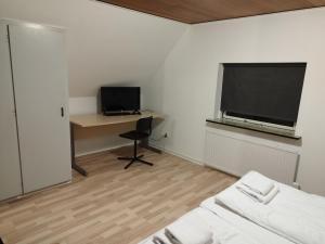 a room with a bed and a desk and a television at Fjeldgaard - Aarup in Årup