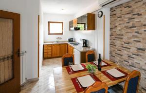 a kitchen and dining room with a wooden table and chairs at Amazing Home In Labin in Labin