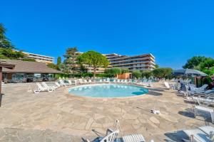 尼斯Superbe 2 pièces Clim et Parking的一个带躺椅的游泳池,一个度假村