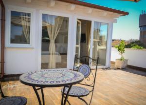 a patio with a table and chairs on a balcony at Il Mare a Roma - Attico Fronte Mare in Lido di Ostia +3 photos