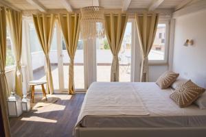 a bedroom with a large bed with yellow curtains at Il Mare a Roma - Attico Fronte Mare in Lido di Ostia