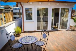 a patio with two chairs and an umbrella at Il Mare a Roma - Attico Fronte Mare in Lido di Ostia