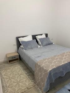a bedroom with a bed with two pillows and a table at Apartament satina in Craiova