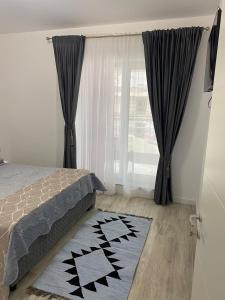 a bedroom with a bed and a window with curtains at Apartament satina in Craiova