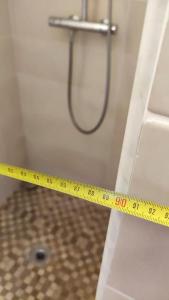 a yellow measuring tape on a bathroom door with a shower at Appartement de 51 m2 avec jardin de 51 m2, parking privé in Achères +28 photos