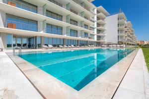 una piscina frente a un edificio en Cond Bayline - T2 - SPA - POOL - GYM - WIFI - Nemo - BY BEDZY, en Armação de Pêra