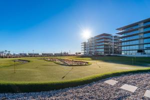 un campo de golf frente a un edificio en Cond Bayline - T2 - SPA - POOL - GYM - WIFI - Nemo - BY BEDZY, en Armação de Pêra