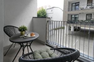 a balcony with a table and chairs and a small table and a tableablish at Sara - Stylish Apt with Balcony near Piata Obor in Bucharest