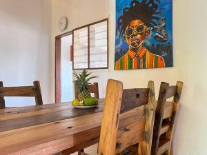 UmbujiにあるStylish 2 Bedroom Apartment - 1 min walk to the Indian Oceanのパイナップルが置かれた木製のテーブルと壁に掛けられた絵
