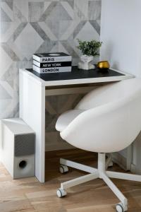 a desk with a white chair and books on it at Sara - Stylish Apt with Balcony near Piata Obor in Bucharest +33 photos